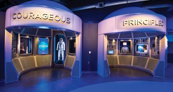 One of the artifact exhibits in “A Hero Is…” features nine interactive exhibits and space program artifacts. Each interactive “pod” is self-contained for content and interactivity, and named after a trait that would be required to become one these heroes, such as Courageous, Passionate or Disciplined. When a visitor comes within a 120º cone around one, an IR emitter triggers activation of a 55-inch LCD/LED display mounted in portrait mode, and a 22-inch touchscreen display.