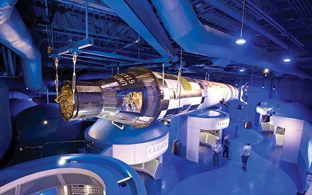 On one side of the Gemini IX-A capsule is a Plexiglas window to the interior designed for two astronauts. On the other side, a custom viewing portal offers a view of a holographic-type effect showing astronaut Gene Cernan on a spacewalk.