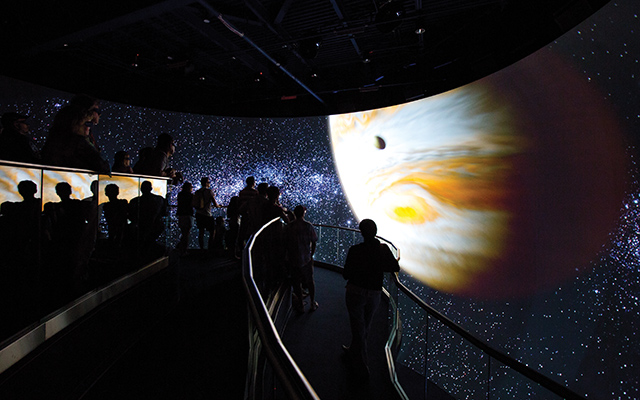 Upon entering and being greeted by a bas-relief of the Mercury 7 astronauts on the façade of the building, visitors ascend a ramp where a seven-minute multimedia presentation unfolds. Two ceiling-mounted projectors display live-action footage on two asymmetrical 16:9 screens.