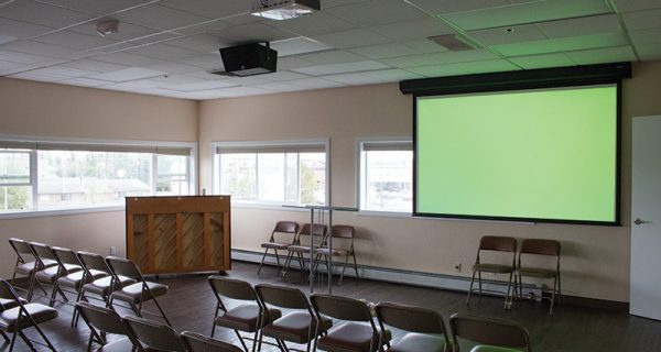 The main sanctuary’s projection screen is hung house right. The off-center location of the screen was chosen to counteract the low ceiling height and keep the ceiling speaker out of the projector’s beam.