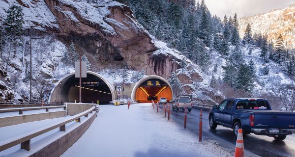 A view of Hanging Lake Tunnels looking to the west. Signs visible here at the bore entry direct traffic and warn drivers of potential hazards ahead. The sign messages are displayed automatically throughout the bores when the operator selects any number of traffic operational modes.
