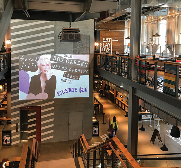 A 6,500-lumen laser projector displays promos on a wall in the central stairwell. 