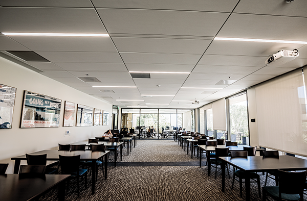 The renovated library has plenty of glass and natural light, which affected projection choices. Projectors that produce 6,500 lumens, like the one seen here, are laser-light-source devices. They replaced the bulb-light source projectors used previously through-out Pepperdine classrooms.