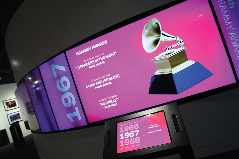 The “Timeline” exhibit’s displays comprise four groups of three Samsung monitors: two 49-inch Samsung 4K LCDs in portrait mode flanking an 85-inch Samsung 4K LCD screen in landscape mode in the center.