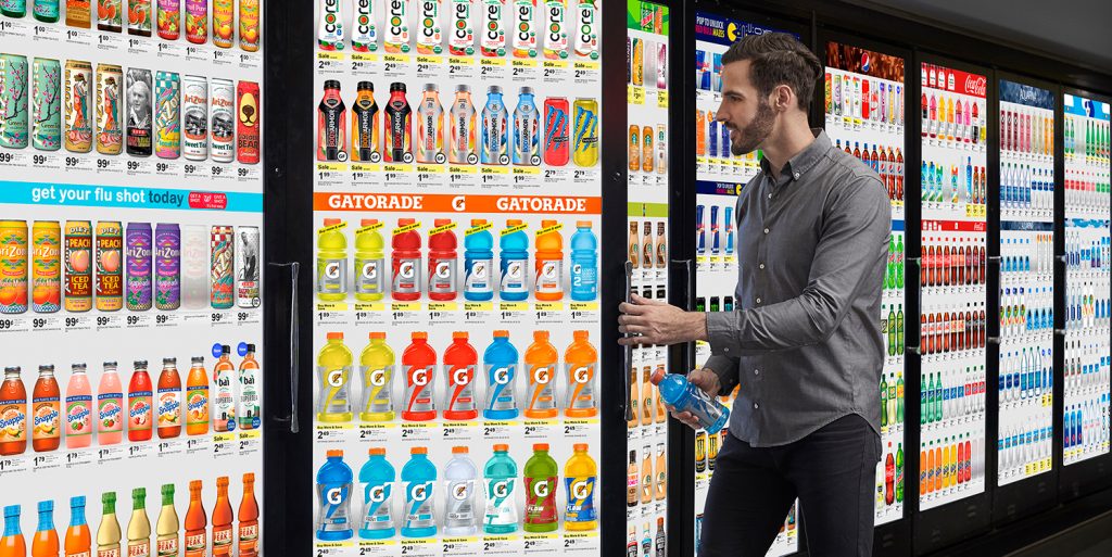 man grabbing beverage from refrigerator with a digital screen