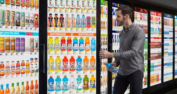 man grabbing beverage from refrigerator with a digital screen